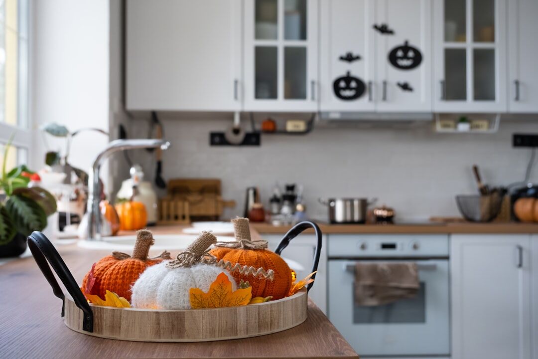 Basket of apples, plums and pumpkins in autumn kitchen